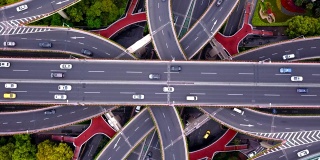 公路交汇处鸟瞰图，形状为字母x交叉。桥梁，道路，或街道与树木的交通概念。中国上海市区建筑的结构形态。