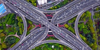公路交汇处鸟瞰图，形状为字母x交叉。桥梁，道路，或街道与树木的交通概念。中国上海市区建筑的结构形态。