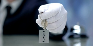 豪华写在钥匙链在接待员的手，优质酒店，特写