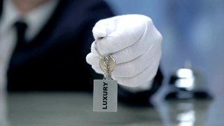 豪华写在钥匙链在接待员的手，优质酒店，特写视频素材模板下载