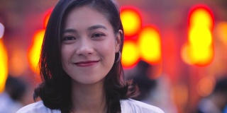 年轻亚洲女孩的肖像与城市背景微笑，4k