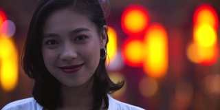 年轻的亚洲女人在晚上对着相机微笑的肖像