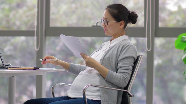 一名中国孕妇在办公室做记录