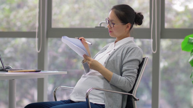 中国怀孕女商人正在办公室工作