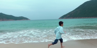 顽皮的男孩在海滩上开始和奔跑