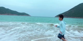顽皮的男孩在海滩上跑步