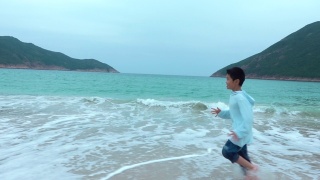 顽皮的男孩在海滩上跑步视频素材模板下载