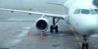 拍摄:恶劣天气飞机在国际机场起飞前与登机桥对接