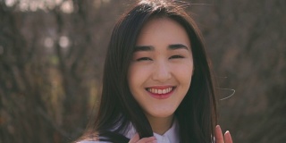成年韩国女学生看着相机，漂亮地笑了。女人快乐又善良