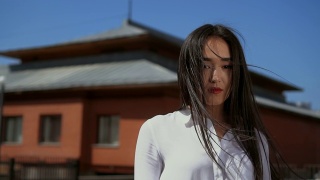 一个日本女孩用慢动作转向镜头。头发落在女人的脸上视频素材模板下载