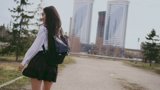 微笑的日本女学生在短裙跳沿着街道课后。视频素材模板下载