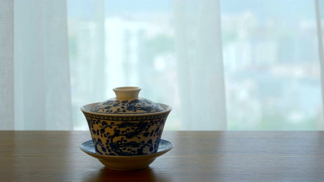 中国茶杯放在窗户旁边的桌子上