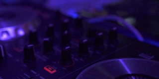 关闭DJ混音播放器和音响控制台为house音乐派对。夜总会混合音乐和彩色灯光的DJ控制器。舞会上的音乐表演及调音台