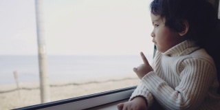 小男孩在火车上看窗外。