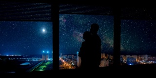 一个男人和一个女人站在可以看到城市夜景的窗边。时间流逝
