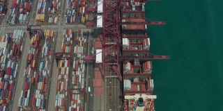 无人机俯视图Pan上方移动的集装箱货船在港口与进出口业务和国际物流航运在城市的货物。吊车在香港维多利亚港的移动速度为4k