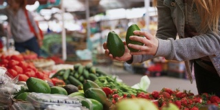 年轻迷人的女人选择有机水果和蔬菜在农贸市场，近距离拍摄