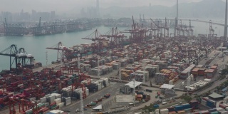 无人机俯视图Pan上方移动的集装箱货船在港口与进出口业务和国际物流航运在城市的货物。吊车在香港维多利亚港的移动速度为4k