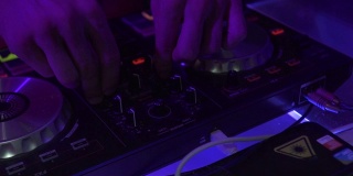 关闭DJ混音播放器和音响控制台为house音乐派对。夜总会里的DJ控制音乐控制台和五彩缤纷的灯光。舞会上的音乐表演及调音台
