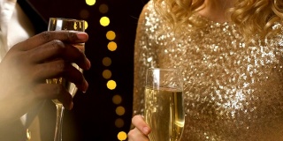 跨种族的情侣在新年派对上碰杯，灯光闪烁，特写镜头