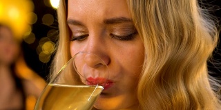 孤独的金发女人在派对和喝香槟时感到嫉妒