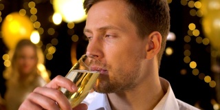 嫉妒不开心的男性在派对上独自喝香槟，而其他人在玩