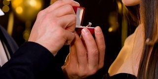 男人在圣诞派对上求婚，并把珍贵的戒指送给惊讶的女士