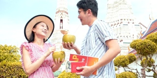 日本游客参观泰国寺庙(wat Aroon)和喝椰子汁。