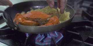 在厨房炉灶上的煎锅里准备意大利面和红海蟹。在餐厅厨房用海鲜制作意大利面食。用新鲜海鲜烹制意大利面