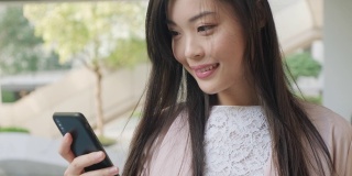 一个中国女商人在城市里使用智能手机的特写