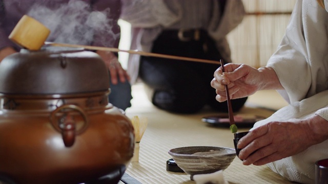 茶道主持人将粉茶舀入碗中