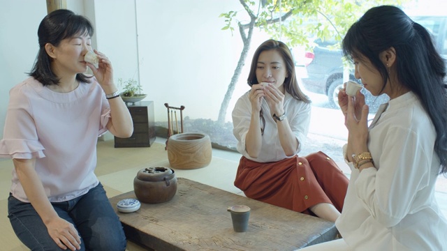 三个中国妇女坐在榻榻米上喝茶