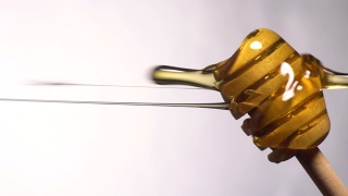 (实时和垂直)蜂蜜从一个木制的蜂蜜勺流动视频素材模板下载