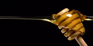(实时和垂直)蜂蜜从一个木制的蜂蜜勺流动