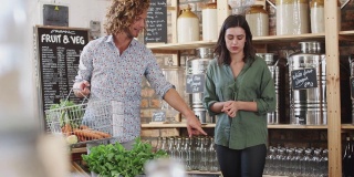 年轻夫妇在可持续的免费塑料杂货店购买新鲜的水果和蔬菜