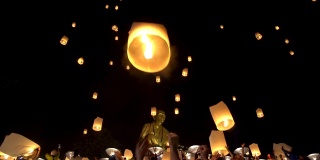 特写手推出浮动灯笼与大佛背景在河灯节，兰芬，泰国北部