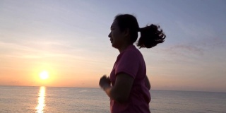 SLO MO美丽的年轻亚洲女子在沙滩上跑步