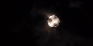特写满月在黑暗的夜晚与云移动它。Motion 4k b-roll footage