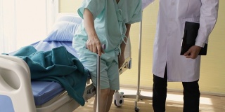 物理治疗师帮助病人从医院的床上走下来。