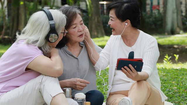 三个台湾老人在公园里听音乐