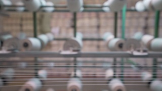 纺织厂工业整经机筒子架上的白色纱线轴视频素材模板下载