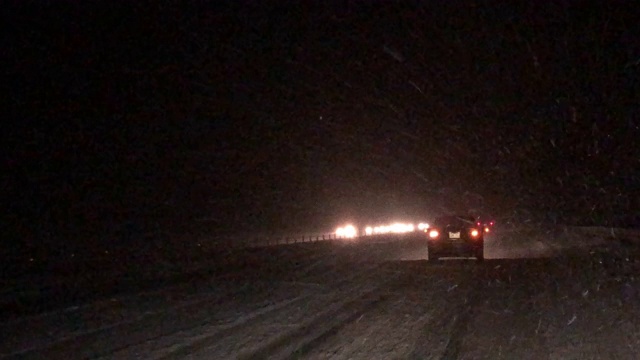 在暴风雪的夜晚，从一辆正在行驶的车辆前方拍摄
