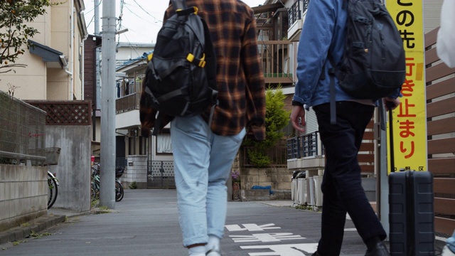 年轻的亚洲背包客在日本的住宅区里行走