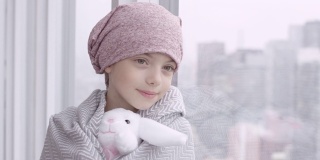 癌症的快乐女孩靠在窗户上