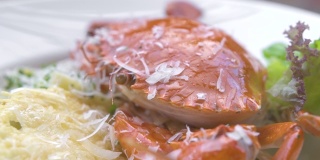 用白盘子盛上红蟹、新鲜香草和奶酪的意大利面。意大利餐厅的传统意大利面配海鲜。食品设计背景。高菜
