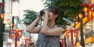 台湾的视频博主在西门的大街上走来走去，用老式相机拍照(慢动作)