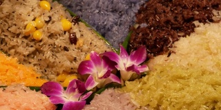 芒果糯米上的奇异花朵。特写美丽的紫色兰花放置在五颜六色的传统泰国糯米甜点