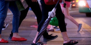 在香港最繁忙的地区，拎着购物袋的顾客穿过街道