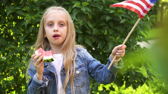 美国纪念或独立日的概念，一个女孩举着美国国旗