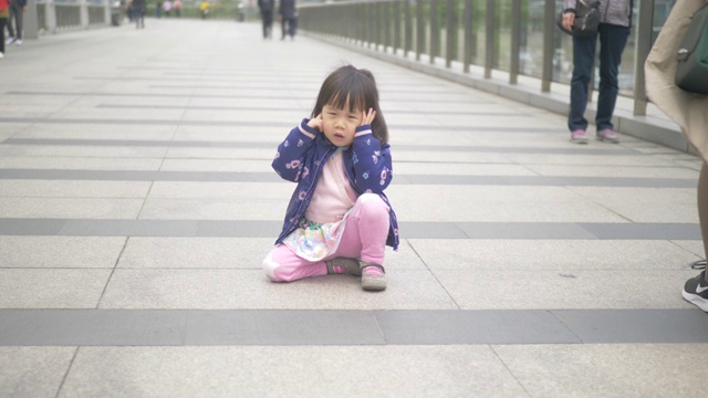 蹒跚学步的女孩走在上海的街道上